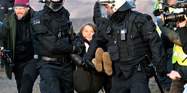 Police officers carry Swedish climate activist Greta Thunberg away from the edge of the Garzweiler II opencast lignite mine during a protest action by climate activists after the clearance of Luetzerath, Germany, Tuesday, Jan. 17, 2023. protests on Tuesday at several locations in North Rhine-Westphalia.