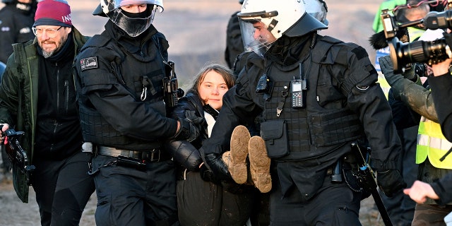 Police officers carry Swedish climate activist Greta Thunberg away from the edge of the Garzweiler II opencast lignite mine during a protest action by climate activists after the clearance of Luetzerath, Germany, Tuesday, Jan. 17, 2023. protests on Tuesday at several locations in North Rhine-Westphalia.