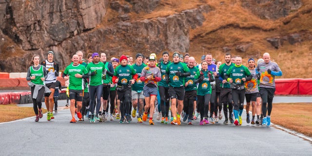 McKee (second from right, front, in green shirt) saw multiple people complete their first marathon after they ran alongside him during his.