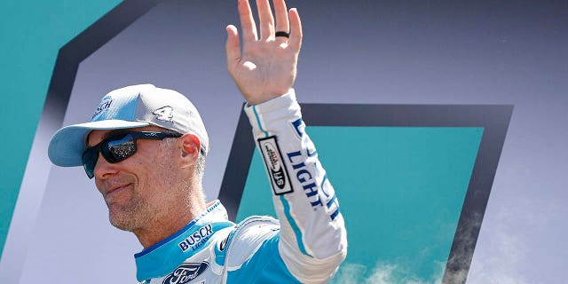 Kevin Harvick, driver of the No. 4 Busch Light Ford, waves to fans as he walks onstage during driver intros prior to the NASCAR Cup Series Dixie Vodka 400 at Homestead-Miami Speedway Oct. 23, 2022, in Homestead, Fla.