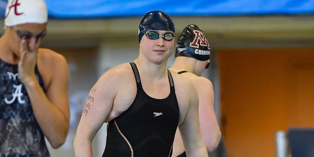 Yale swimmer Iszac Henig on the starting block with "Let trans kids play" written on her arm during the 100 Freestyle prelims at the NCAA Swimming and Diving Championships on March 19th, 2022, at the McAuley Aquatic Center in Atlanta, Georgia.