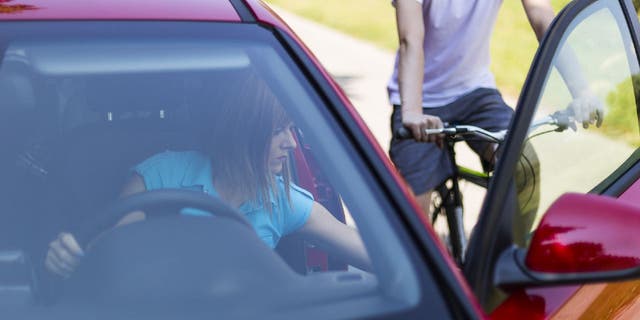 Woman improperly opens a car door and puts a cyclist in great danger on the road.