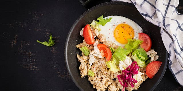 Savory oatmeal has become a trendy social media dish that's made with non-sweet ingredients. Here's an example with a fried egg, sliced tomatoes, lettuce and purple onions.
