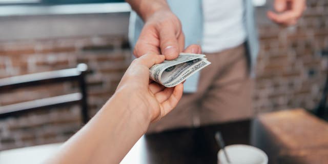 Money being exchanged between two people