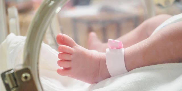 Baby girl with pink hospital anklet