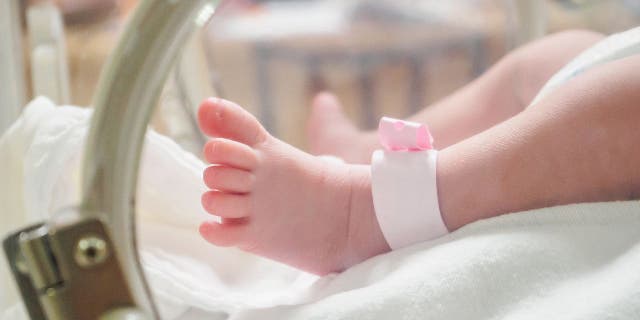 Baby girl with pink hospital anklet