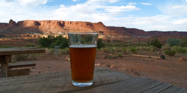 A glass of beer sits on a picnic table at Capitol Reef National Park.