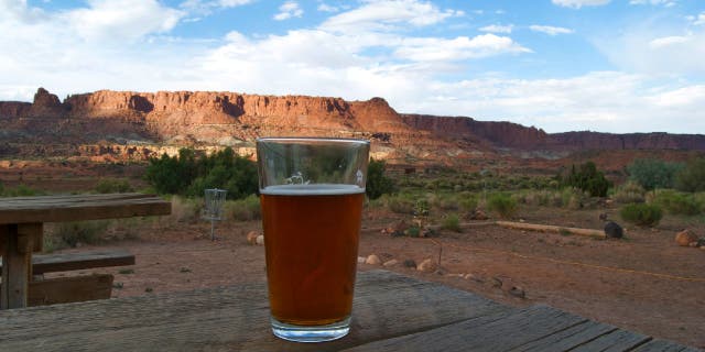 A glass of beer sits on a picnic table at Capitol Reef National Park.