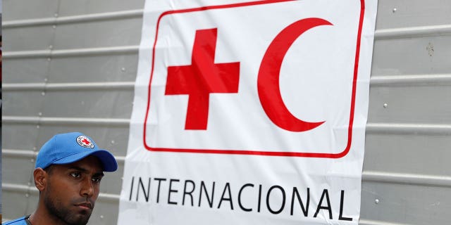 A worker of Venezuelan Red Cross walks past a truck with the logo of the International Federation of Red Cross and Red Crescent Societies in Caracas, on April 16, 2019.