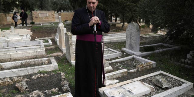 Hussam Naoum, a Palestinian Anglican bishop, pauses as vandals desecrate more than 30 graves at the historic Protestant cemetery on Jerusalem's Mount Zion in Jerusalem, Wednesday, January 4, 2023.