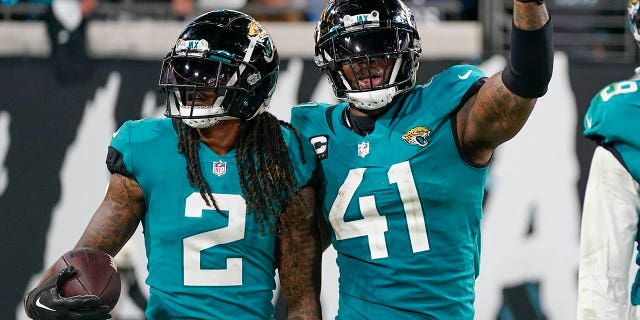 El apoyador de los Jacksonville Jaguars Josh Allen (41) y el profundo Rayshawn Jenkins (2) celebran su golpe que forzó un balón suelto y su regreso para un touchdown en la segunda mitad de un partido de fútbol americano de la NFL contra los Tennessee Titans, el sábado 7 de enero de 2023. en Jacksonville, Florida