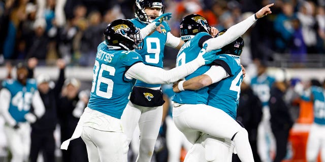 Riley Patterson # 10 de los Jacksonville Jaguars celebra con sus compañeros de equipo después de anotar un gol de campo para derrotar a Los Angeles Chargers 31-30 en el juego de playoffs AFC Wild Card en TIAA Bank Field el 14 de enero de 2023 en Jacksonville, Florida.