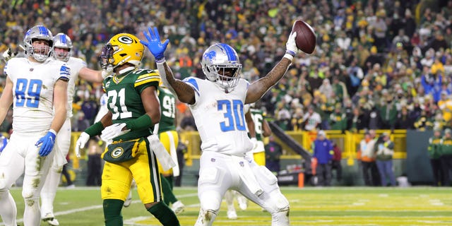 Jamaal Williams #30 of the Detroit Lions celebrates with teammates after a touchdown during the third quarter against the Green Bay Packers at Lambeau Field on January 8, 2023 in Green Bay, Wisconsin.