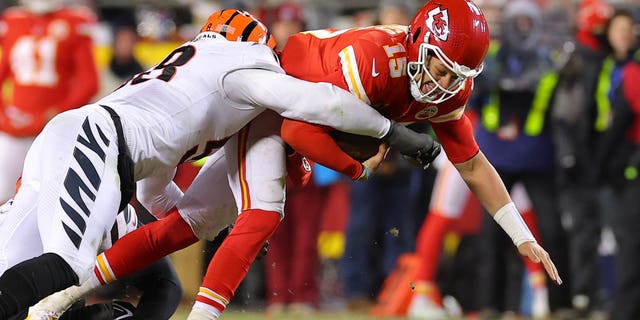 Joseph Ossai, #58, and Zach Carter, #95 of the Cincinnati Bengals, tackle Patrick Mahomes, #15 of the Kansas City Chiefs, during the fourth quarter in the AFC Championship Game at GEHA Field at Arrowhead Stadium on Jan. 29, 2023 in Kansas City, Missouri.