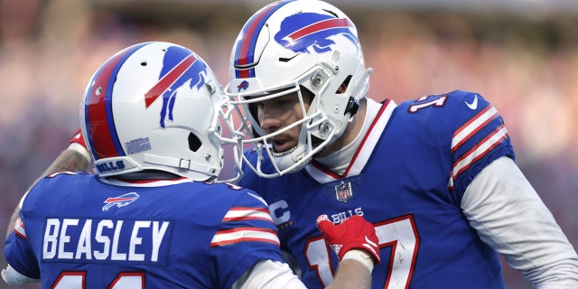 El receptor abierto de los Buffalo Bills, Cole Beasley (11), a la izquierda, es felicitado por el mariscal de campo Josh Allen después de su atrapada de touchdown durante la segunda mitad de un partido de fútbol americano de playoffs de la NFL contra los Miami Dolphins, el domingo 15 de enero de 2023, en Orchard Parc, Nueva York.