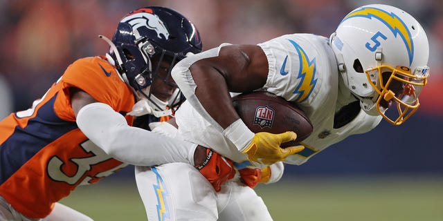 Ja'Quan McMillian #35 of the Denver Broncos tackles Joshua Palmer #5 of the Los Angeles Chargers during the fourth quarter at Empower Field At Mile High on January 8, 2023 in Denver, Colorado.
