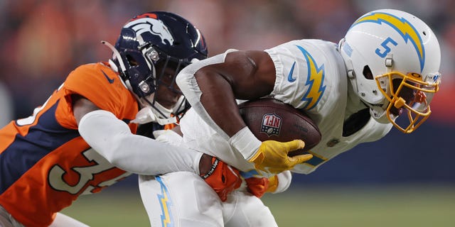 Ja'Quan McMillian #35 of the Denver Broncos tackles Joshua Palmer #5 of the Los Angeles Chargers during the fourth quarter at Empower Field At Mile High on January 8, 2023 in Denver, Colorado.