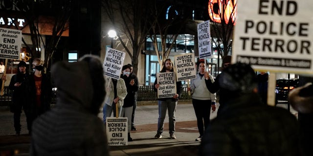 Protesters hold signs during a rally against the fatal police assault of Tyre Nichols, in Atlanta, on January 27, 2023. - The US city of Memphis released January 27, 2023 graphic video footage depicting the fatal police assault of a 29-year-old Black man, as cities nationwide braced for a night of protests against police brutality. Five Memphis officers, also all Black, were charged with second-degree murder in the beating of Tyre Nichols, who died in hospital on January 10 three days after being stopped on suspicion of reckless driving. 
