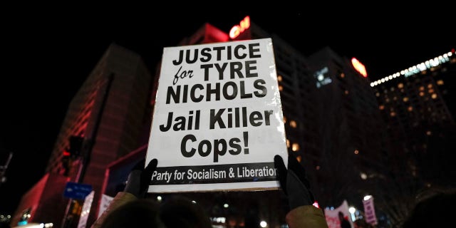 A protestor holds a sign reading "Justice for Tyre Nichols, Jail Killer Cops" during a rally against the fatal police assault of Tyre Nichols, in Atlanta, on January 27, 2023.