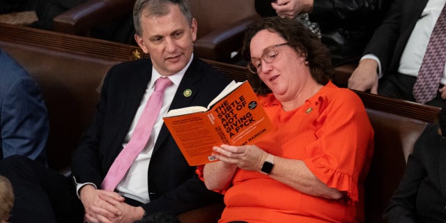 Rep. Katie Porter, D-Calif., shows her book to Rep. Sean Casten, D-Ill., during the 15th vote to elect a Speaker of the House early Saturday morning, Jan. 7, 2023.