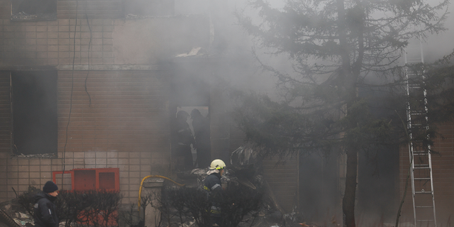 Emergency personnel work at the site of a helicopter crash in the town of Brovary, outside Kyiv, Ukraine.