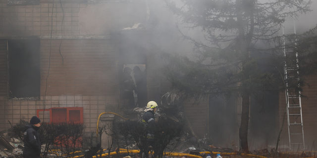 Emergency personnel work at the site of a helicopter crash in the town of Brovary, outside Kyiv, Ukraine.