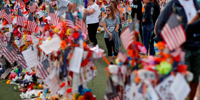 FILE - People visit a makeshift memorial honoring the victims of the Oct. 1 mass shooting on Nov. 12, 2017, in Las Vegas. 