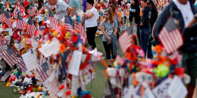 FILE - People visit a makeshift memorial honoring the victims of the Oct. 1 mass shooting on Nov. 12, 2017, in Las Vegas. 