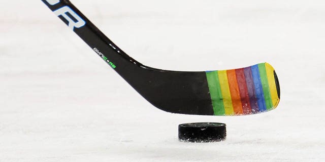 Zac Jones de los New York Rangers patina con un palo decorado para "noche de orgullo" durante los calentamientos antes de un partido contra los Washington Capitals en el Madison Square Garden el 3 de mayo de 2021 en la ciudad de Nueva York. 