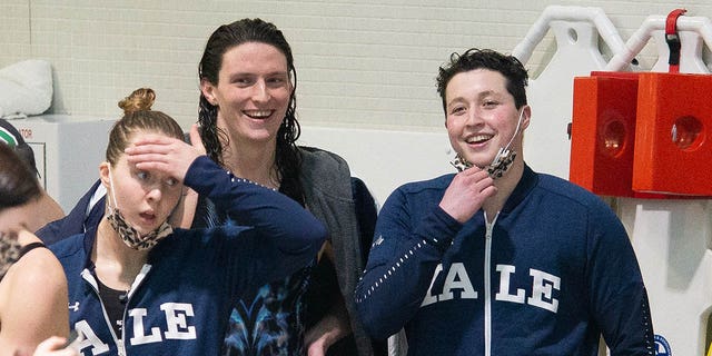 University of Pennsylvania swimmer Lia Thomas (center) smiles with Yale University swimmer Iszac Henig (right) after winning the 100-yard freestyle during the Ivy Women's Swimming and Diving Championships League 2022 at Blodgett Pool on February 19, 2022, in Cambridge, Massachusetts.