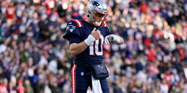 Mac Jones of the New England Patriots checks out a play against the Miami Dolphins on January 1, 2023 in Foxborough, Massachusetts.