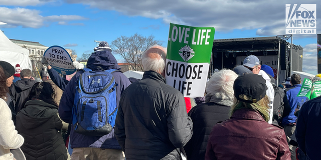 A man stands with a sign at the 2023 March for Life rally in Washington, DC