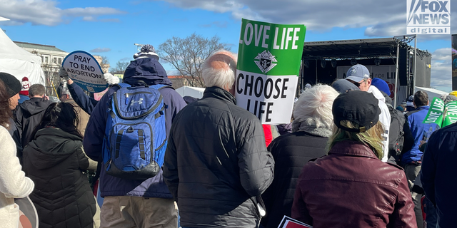 A man stands with a sign at the 2023 March for Life rally in Washington, DC