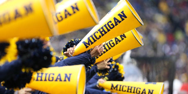 Michigan cheerleaders yell into their megaphones during a Big Ten Conference regular season college football game between the Nebraska Cornhuskers and the Michigan Wolverines on November 12, 2022, at Michigan Stadium in Ann Arbor, Michigan. 