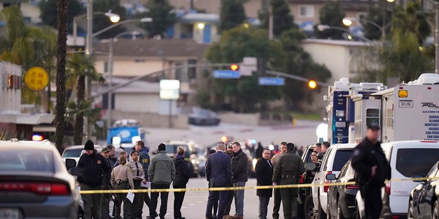 Law enforcement personnel gather outside a ballroom dance club in Monterey Park, Calif., Sunday, Jan. 22, 2023. A mass shooting took place at the dance club following a Lunar New Year celebration, setting off a manhunt for the suspect.