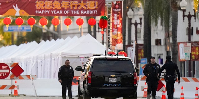 Police officers stand outside a ballroom dance club in Monterey Park, Calif., Sunday, Jan. 22, 2023. A mass shooting took place at a dance club following a Lunar New Year celebration, setting off a manhunt for the suspect.