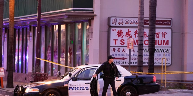 Een politieagent stapt uit zijn voertuig in de buurt van een dansclub in Monterey Park, Californië, zondag 22 januari 2023. Een massale schietpartij vond plaats in een dansclub na een viering van het nieuwe maanjaar, wat leidde tot een klopjacht op de verdachte.