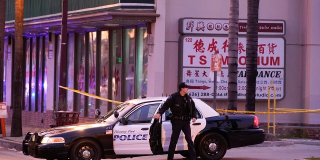 A police officer gets out of his vehicle near a ballroom dance club in Monterey Park, Calif., Sunday, Jan. 22, 2023. A mass shooting took place at a dance club following a Lunar New Year celebration, setting off a manhunt for the suspect.