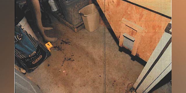 Alex Murdaugh crime scene photo showing a dummy near where Paul Murdaugh was shot. Droplets of blood and a yellow evidence marker can be seen on the floor of the feedroom.
