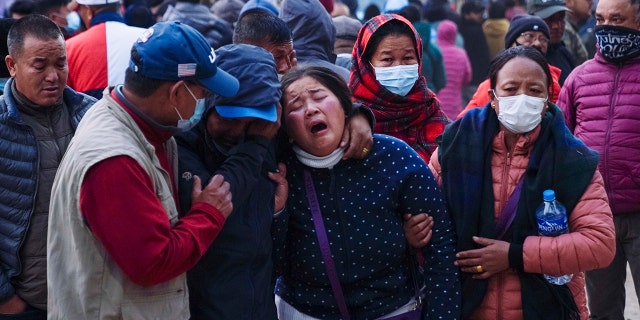 A woman cries as the body of a relative, victim of a plane crash, is brought to a hospital in Pokhara, Nepal, Sunday, Jan. 15, 2023. A plane making a 27-minute flight to a Nepal tourist town crashed into a gorge Sunday while attempting to land at a newly opened airport, killing at least 68 of the 72 people aboard. At least one witness reported hearing cries for help from within the fiery wreck, the country’s deadliest airplane accident in three decades.