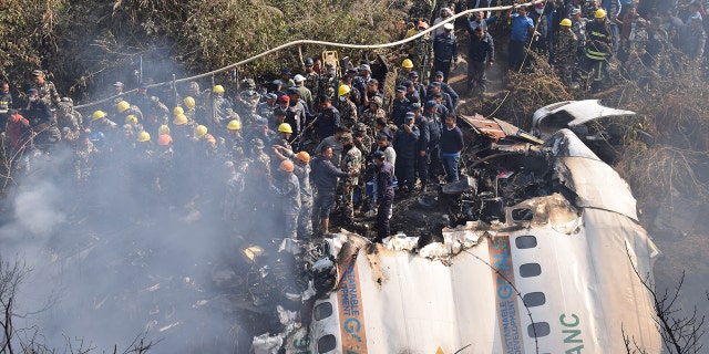 Nepalese rescue workers and civilians gather around the wreckage of a passenger plane that crashed in Pokhara, Nepal, Sunday, Jan. 15, 2023. Authorities in Nepal said 68 people have been confirmed dead after a regional passenger plane with 72 aboard crashed into a gorge while landing at a newly opened airport in the resort town of Pokhara. It's the country's deadliest airplane accident in three decades.