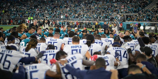 Los jugadores de los Tennessee Titans y los Jacksonville Jaguars se reúnen en el campo para rezar por la jugadora lesionada de los Buffalo Bills, Damar Hamlin, antes de un partido el sábado 7 de enero de 2023 en Jacksonville, Florida.