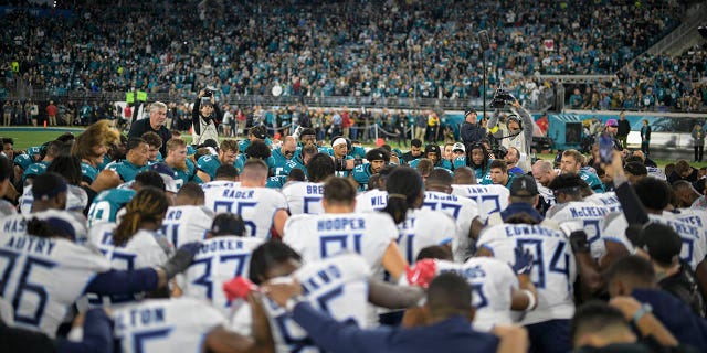 Tennessee Titans and Jacksonville Jaguars players gather on the field to pray for injured Buffalo Bills player Damar Hamlin before a game on Saturday, Jan. 7, 2023, in Jacksonville, Florida.