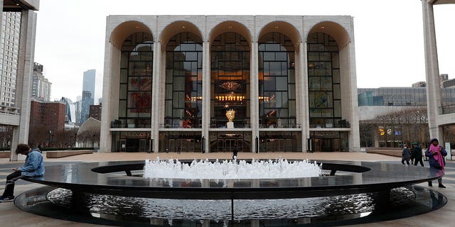 People appear in Josie Robertson Plaza in front of The Metropolitan Opera house in New York City on March 12, 2020.