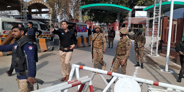 Des soldats de l'armée et des policiers ouvrent la voie aux ambulances qui se précipitent vers un site d'explosion d'une bombe.