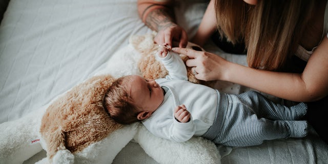 parents and baby on bed