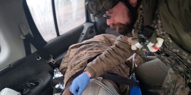Polish paramedic Damian Duda attends to an injured soldier in Soledar, Ukraine, on January 2023.