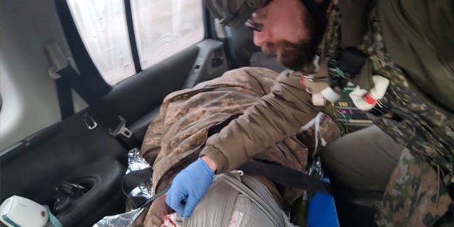 Polish paramedic Damian Duda attends to an injured soldier in Soledar, Ukraine, on January 2023.