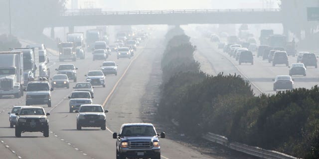 California has some of the worst soot-polluted cities in the nation. Pictured: Cars drive through a foggy atmosphere in Fresno, California, on Dec. 28, 2017.