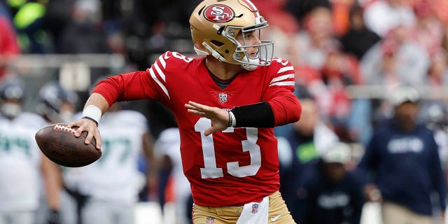 El mariscal de campo de los 49ers de San Francisco, Brock Purdy (13), pasa contra los Seahawks de Seattle en la primera mitad de un juego de comodines de la NFL en Santa Clara, California, el sábado 14 de enero de 2023.